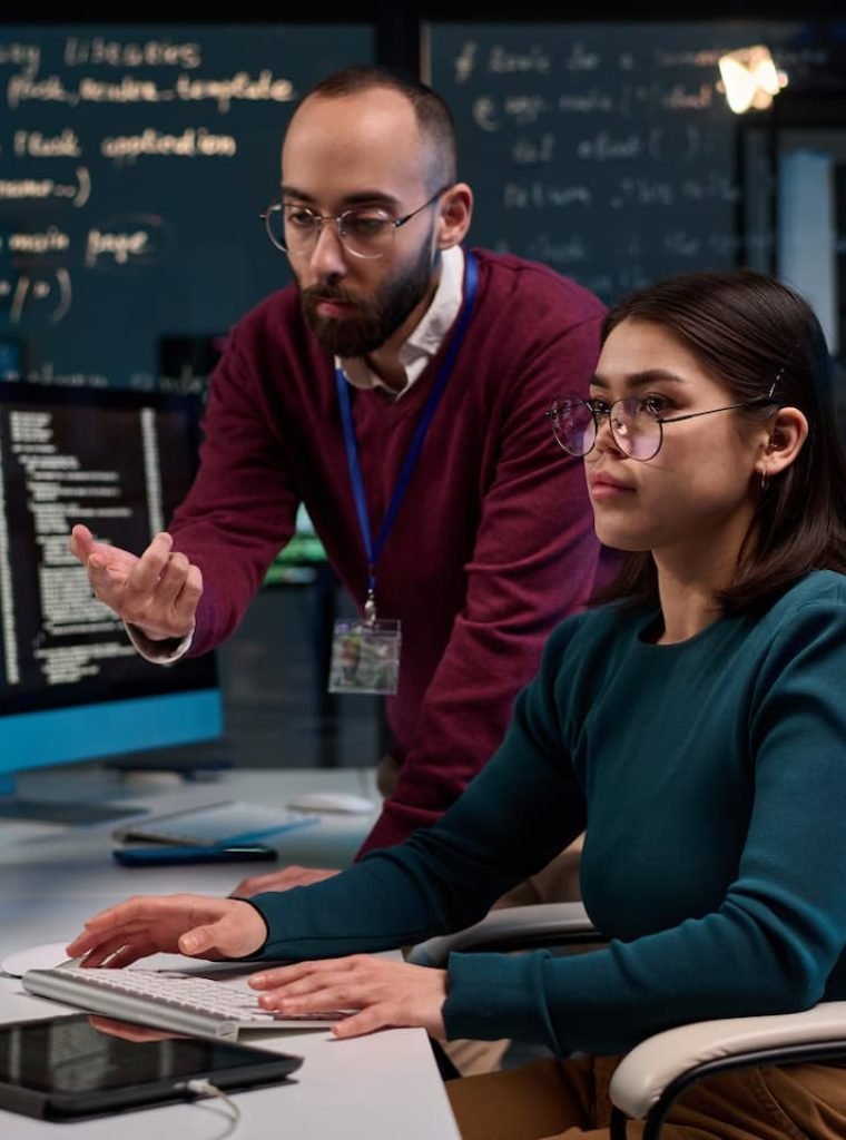 girl-using-computer-with-mentor-giving-advice-GGNY9A9